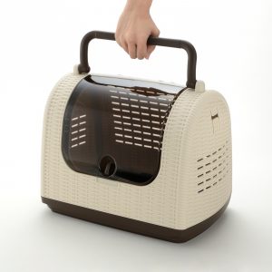 demonstrating how to carry handle of wicker pet carrier